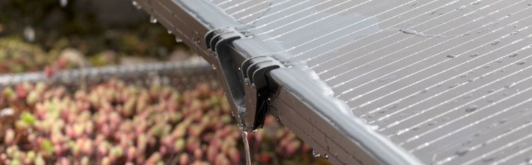 Dräneringsklämma för solpanel installerad på en solpanel som visar vattendräneringen